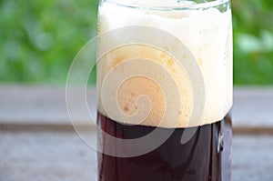 Glass of beer foam over wooden table