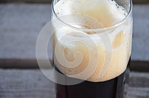 Glass of beer foam over wooden table