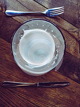 glass of beer, fork and knife on wooden table