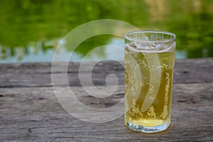 A glass of beer with ice on wooden table, drinking in hot Asian country with cool soft drink