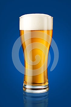Glass of beer isolated on blue background, retouched to perfection