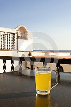 Glass of beer with lemon near the sea.