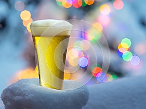 Glass of beer with magic Christmas lights at the background