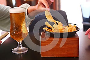 glass of beer and nachos chips close up photo on summer restaurant terrace background