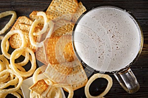 Glass of beer  and onion rings and a cracker , drink with snacks, top view