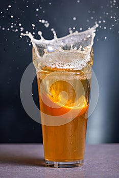 A glass of beer with an orange slice in it