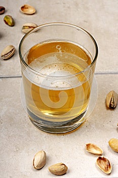 A glass of beer and pistachios
