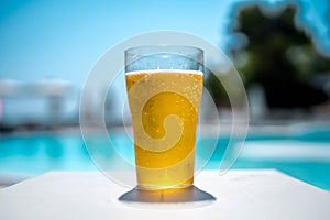 Glass of beer by the pool