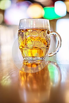 Glass of beer in pub, hand of bartender pouring a large lager beer in tap, the beer taps in a pub