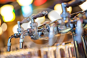 Glass of beer in pub, hand of bartender pouring a large lager beer in tap, the beer taps in a pub.