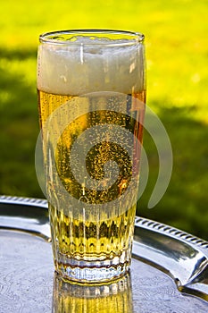 A glass of beer silver on a tray
