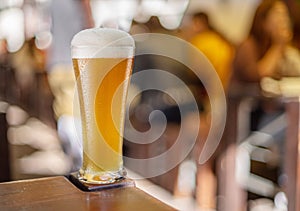 Glass of beer stands on a table in a pub. White unfiltered beer photo