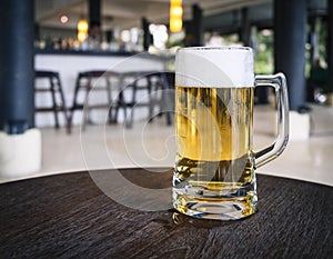 Glass of Beer on table with Blurred Bar counter background