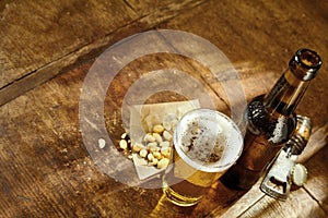 Glass of Beer on Table with Opener and Peanuts
