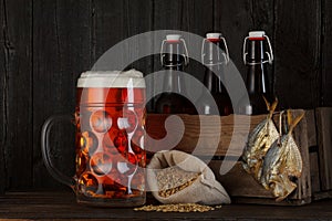 Glass of beer on table with wooden crate full of bottles