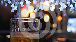 glass of beer under blurry lights
