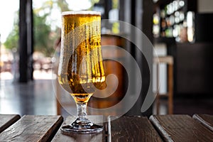 Glass of beer on a wooden table in a pub, bar. Alcohol drink. Party, leisure concept