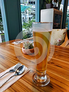 Glass of beer on wooden table in restaurant