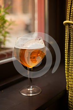 A glass with Belgian beer on the window