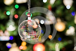 Glass bell of reindeer ornament hanging on Christmas tree