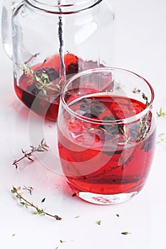 Glass of berry drink with fresh fruits on marble table