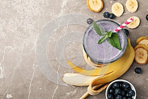 Glass berry milkshake on gray table. Summer drink