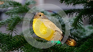 A glass bird on a coniferous tree branch