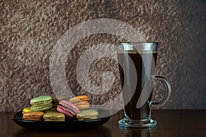 Glass of Black Coffee with Macaron Biscuits on a Wooden Table Top