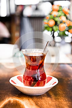 A glass of black Turkish tea on wooden table