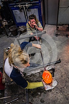 Two Women Shaping Blown Glass on the Blowpipe