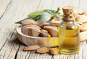 Glass bottle of Almond oil and almond nuts