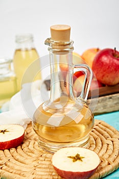 Glass Bottle of apple organic vinegar on blue background
