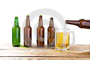 Glass and bottle of beer with no logos on wooden table isolated copy space, bottle mock up. Beer bottle studio shot with cap