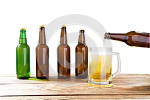 Glass and bottle of beer with no logos on wooden table isolated copy space, bottle mock up. Beer bottle studio shot with cap