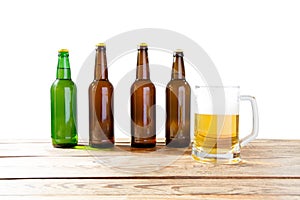 Glass and bottle of beer with no logos on wooden table isolated copy space, bottle mock up. Beer bottle studio shot with cap