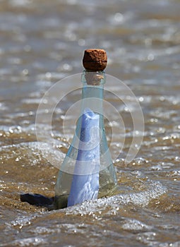 glass bottle containing a secret message washed ashore by sea currents