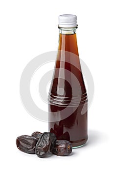 Glass bottle with date vinegar and dried dates in front on white background