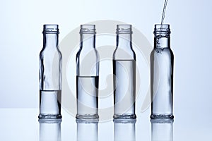 Glass bottle with different water levels photo