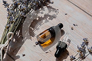 Glass bottle dropper with dried lavender flowers. Wild harvested essential oil beauty product. Organic herbs skincare