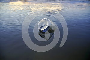 Glass bottle floats adrift in water