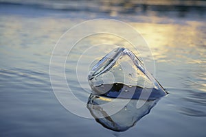 Glass bottle floats adrift in water