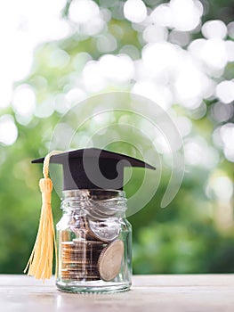 Glass bottle with graduation hat. The concept of saving money for education, student loan, scholarship, tuition fees in future