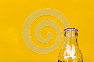 Glass bottle, half bottle on yellow background