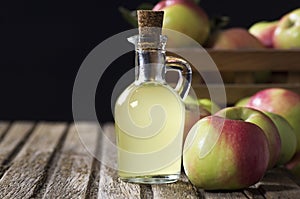 Glass bottle of handmade organic apple cider vinegar made from fermented fresh ripe apples