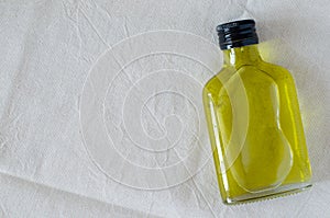 Glass bottle of hempseed oil on linen background with copy space