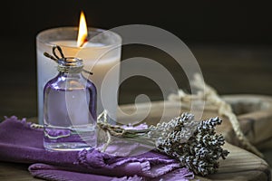 Glass bottle Lavender essential oil dried seed aromatherapy spa massage concept. herb Purple candle wood table background sea