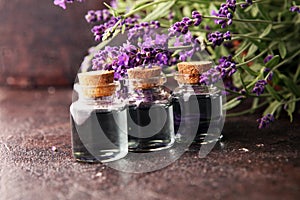 Glass bottle of Lavender essential oil with fresh lavender flowers for healthy aromatherapy spa massage concept on table