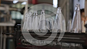 Glass bottle manufacturing, transporter belt closeup