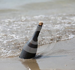 bottle with a message transported from the sea to the shore photo