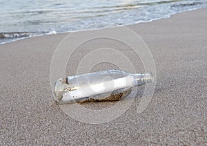 Glass bottle with note message on tropical beach